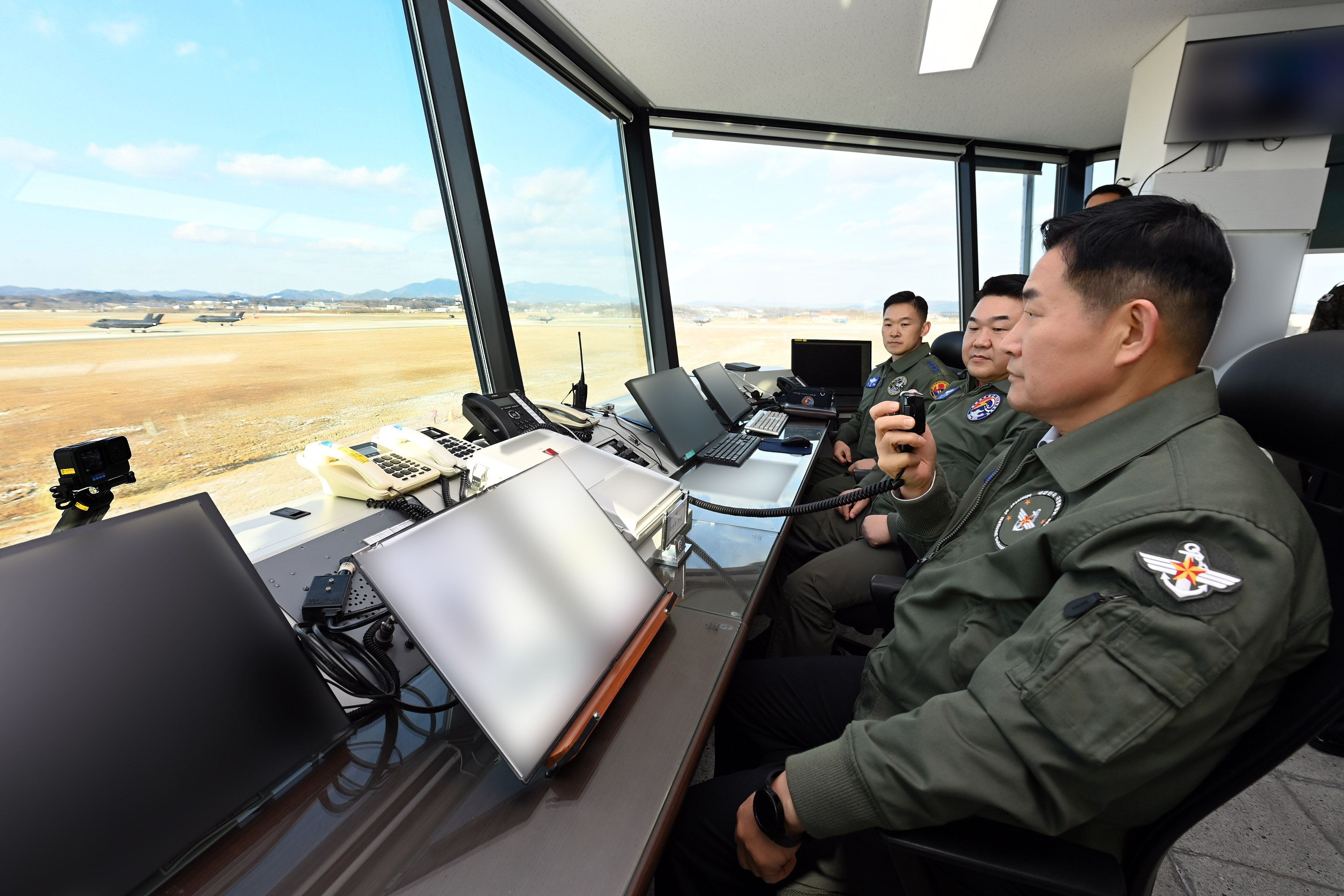 신원식(맨 오른쪽) 국방장관이 24일 17전투비행단을 찾아 활주로 통제소(런웨이 컨트롤)에서  F-35A 전투기 출격현장 작전지도를 하고 있다. /국방부