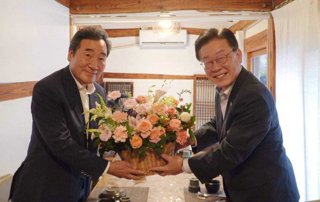 더불어민주당 이재명(오른쪽) 대표와 이낙연 전 대표가 28일 서울 모처에서 만찬 회동을 하며 꽃바구니를 들고 기념 촬영을 하고 있다. /더불어민주당