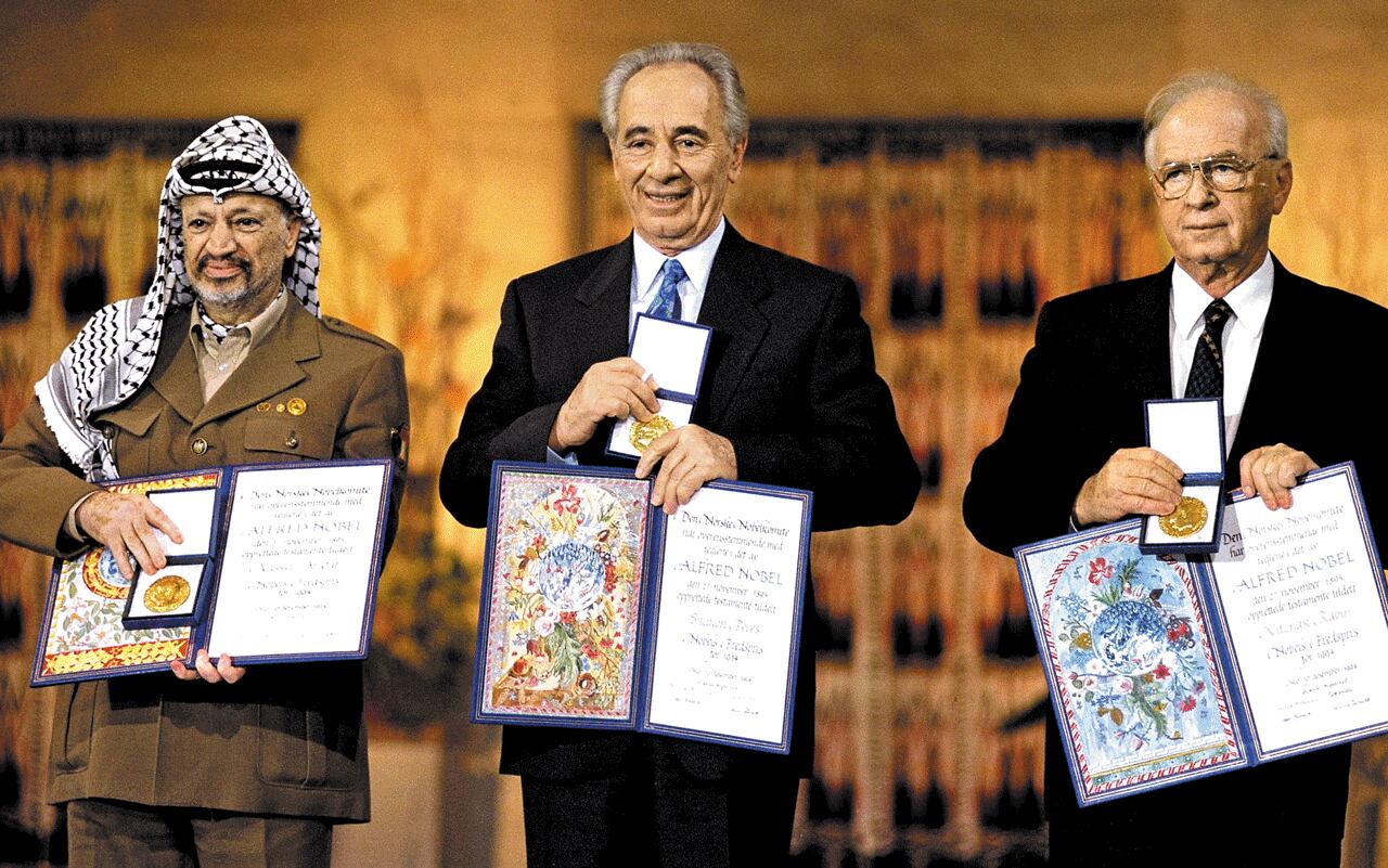 1994년 12월 노르웨이에서 열린 노벨평화상 시상식에 수상자로 참석한 시몬 페레스 당시 이스라엘 외무장관(가운데)이 공동 수상자인 야세르 아라파트 팔레스타인 해방기구 의장(왼쪽)과 이츠하크 라빈 당시 이스라엘 총리와 함께 나란히 서서 노벨평화상 메달과 수상증서를 내보이고 있다. 조국 이스라엘의 군사력을 일취월장시킨 뒤 페레스는 평화 정착에 주력했고, 주변의 반대를 무릅쓰고 1993년 오슬로 평화협정 체결에 앞장섰다. /게티이미지코리아