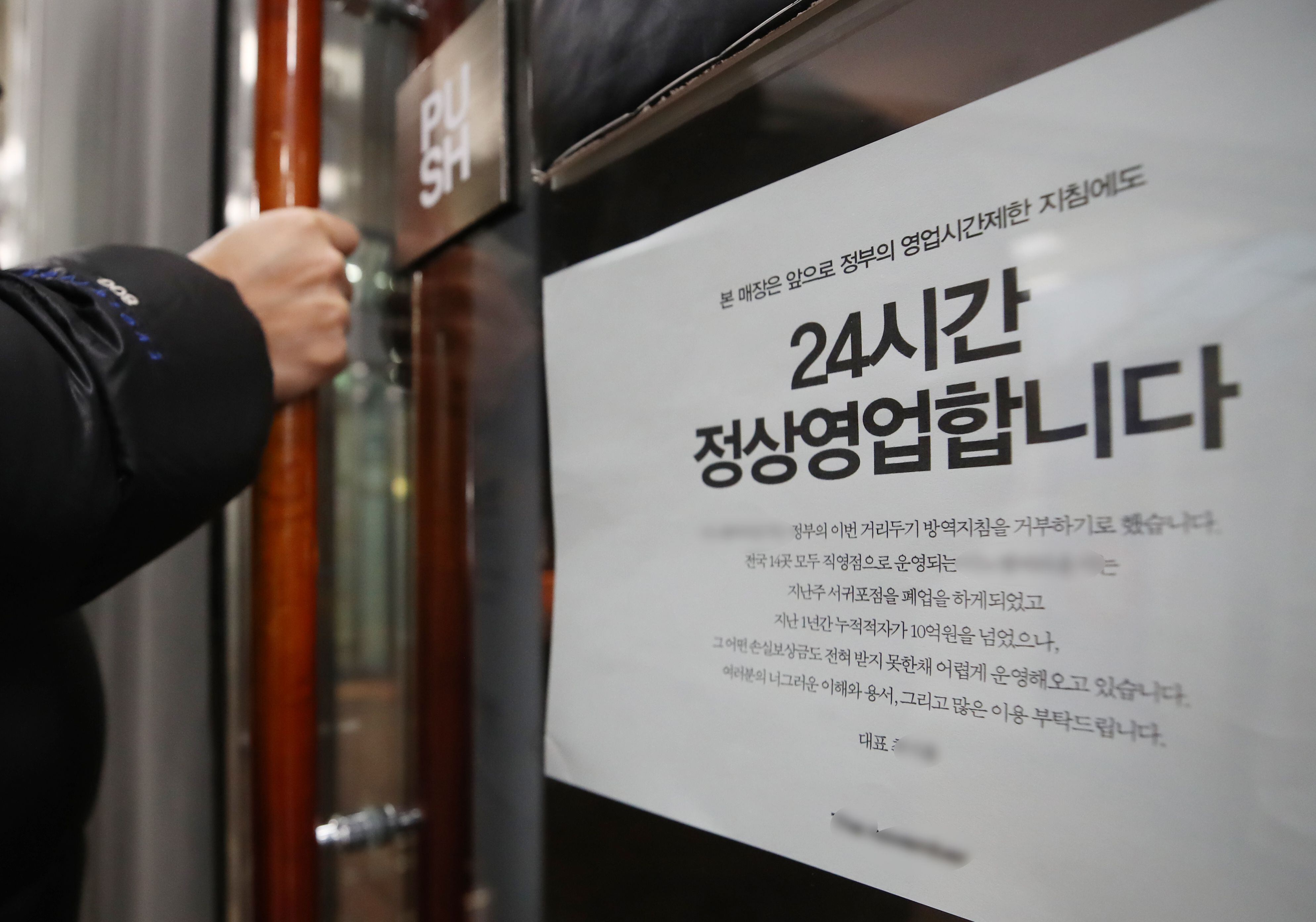 지난 21일 인천의 한 대형 카페 직영점에 '정부의 방역지침을 거부, 24시간 정상 영업'을 알리는 안내문이 붙어 있다. /연합뉴스