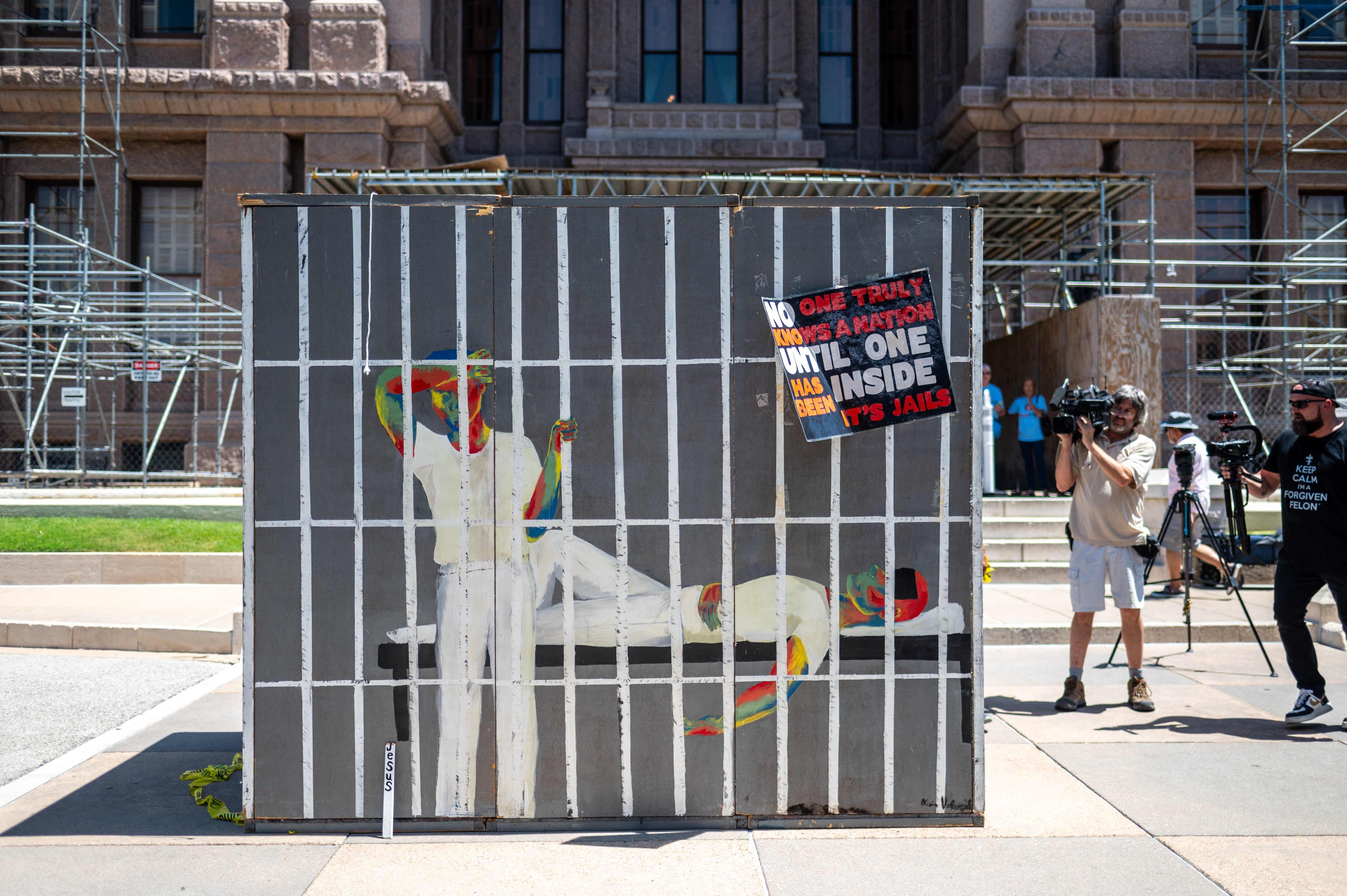지난달 18일 텍사스 주의회 앞에 감옥 그림이 그려진 간이 시설물이 놓여 있다. 에어컨 없는 좁은 공간을 체험해 보도록 활동가들이 설치했다. /AFP 연합뉴스