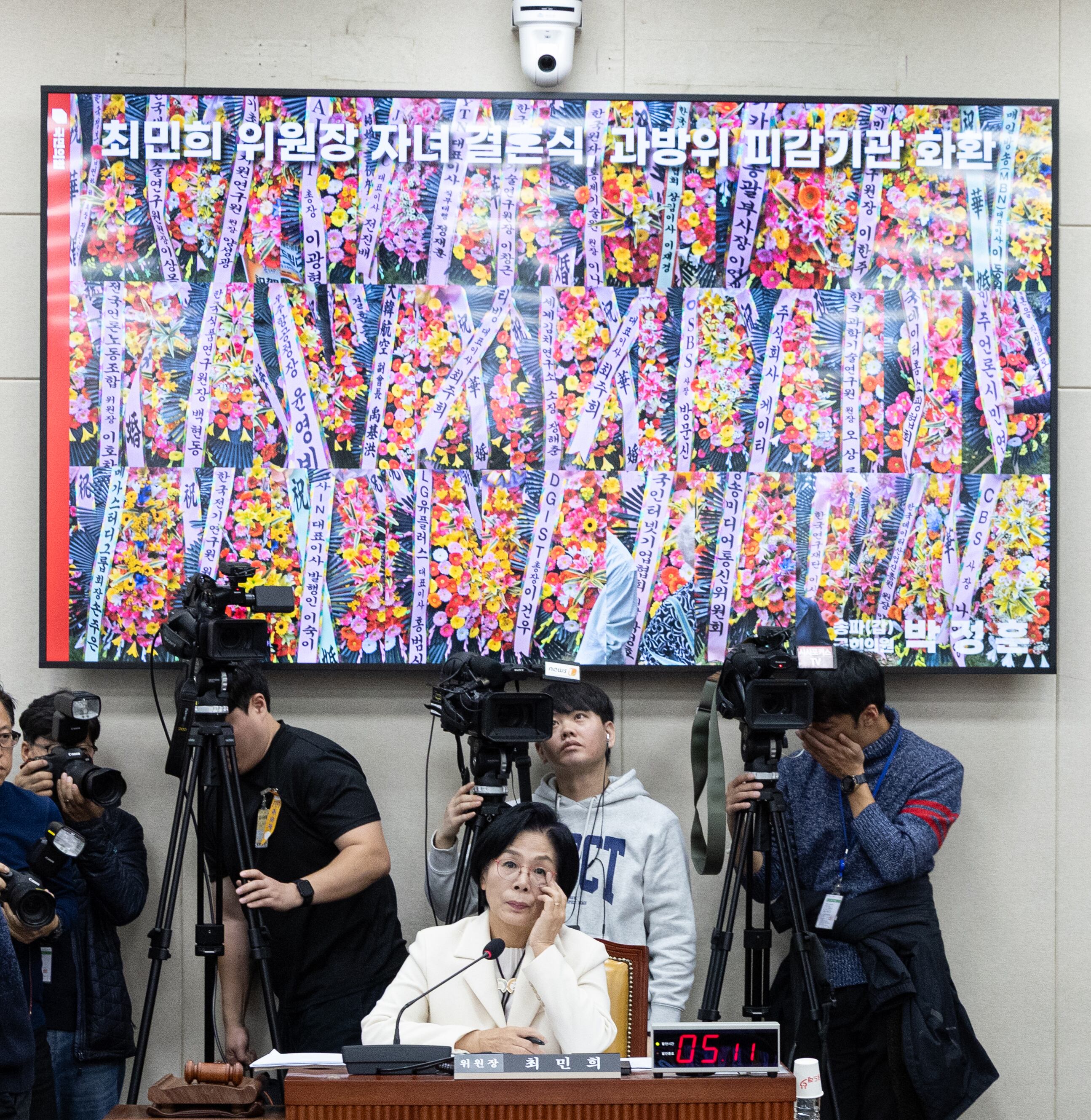 지난달 29일 국회 과방위 국정감사에서 야당 의원들이 최민희 위원장 딸 결혼식장을 뒤덮은 피감기관들 화환 사진을 띄워놓은 채 질의하고 있다./뉴스1
