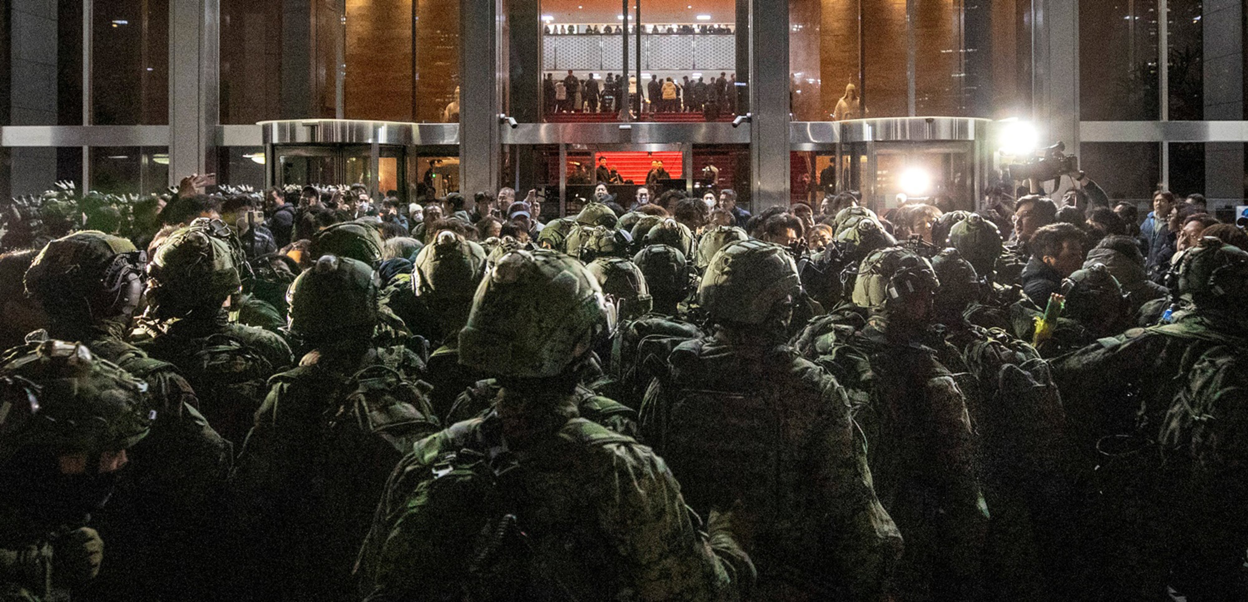 2024년 12월 4일 새벽, 비상계엄 선포 직후 국회에 투입된 계엄군이 국회 본관 정문 앞에서 국회 사무처 직원과 보좌진 등과 대치하고 있다. 계엄군은 정문 진입이 막히자 본관 유리창을 깨고 내부로 들어갔지만, 계엄 해제 요구안 표결이 진행된 본회의장에는 진입하지 못했다. 당시 국회에 투입된 계엄군은 약 280명으로 추정됐다. /김지호 기자