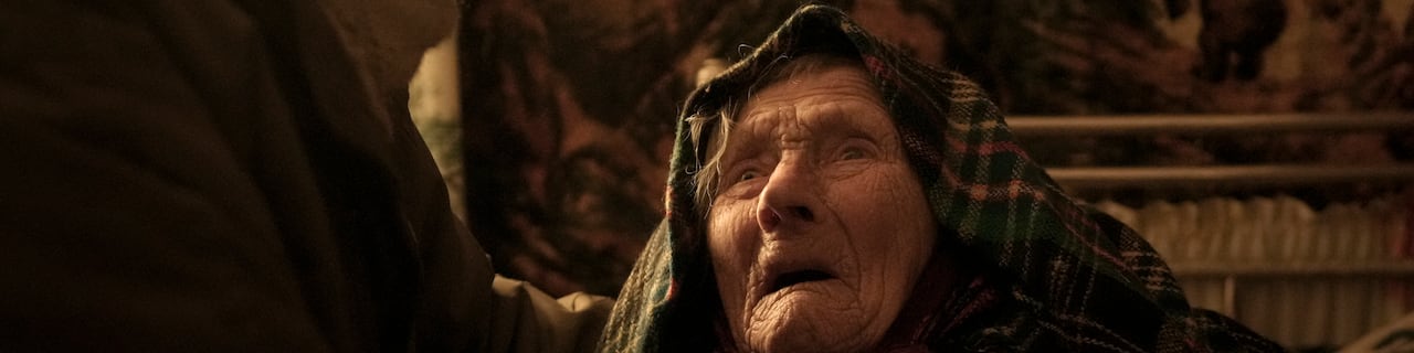 러시아 점령으로 정신적 충격을 받은 모트리아 올렉시엔코(99)가 2022년 4월 6일 수요일 러시아군과 우크라이나군의 교전으로 큰 피해를 입은 우크라이나 안드리우카 마을의 난방이 없는 방에서 가족의 위로를 받고 있다./AP 연합뉴스