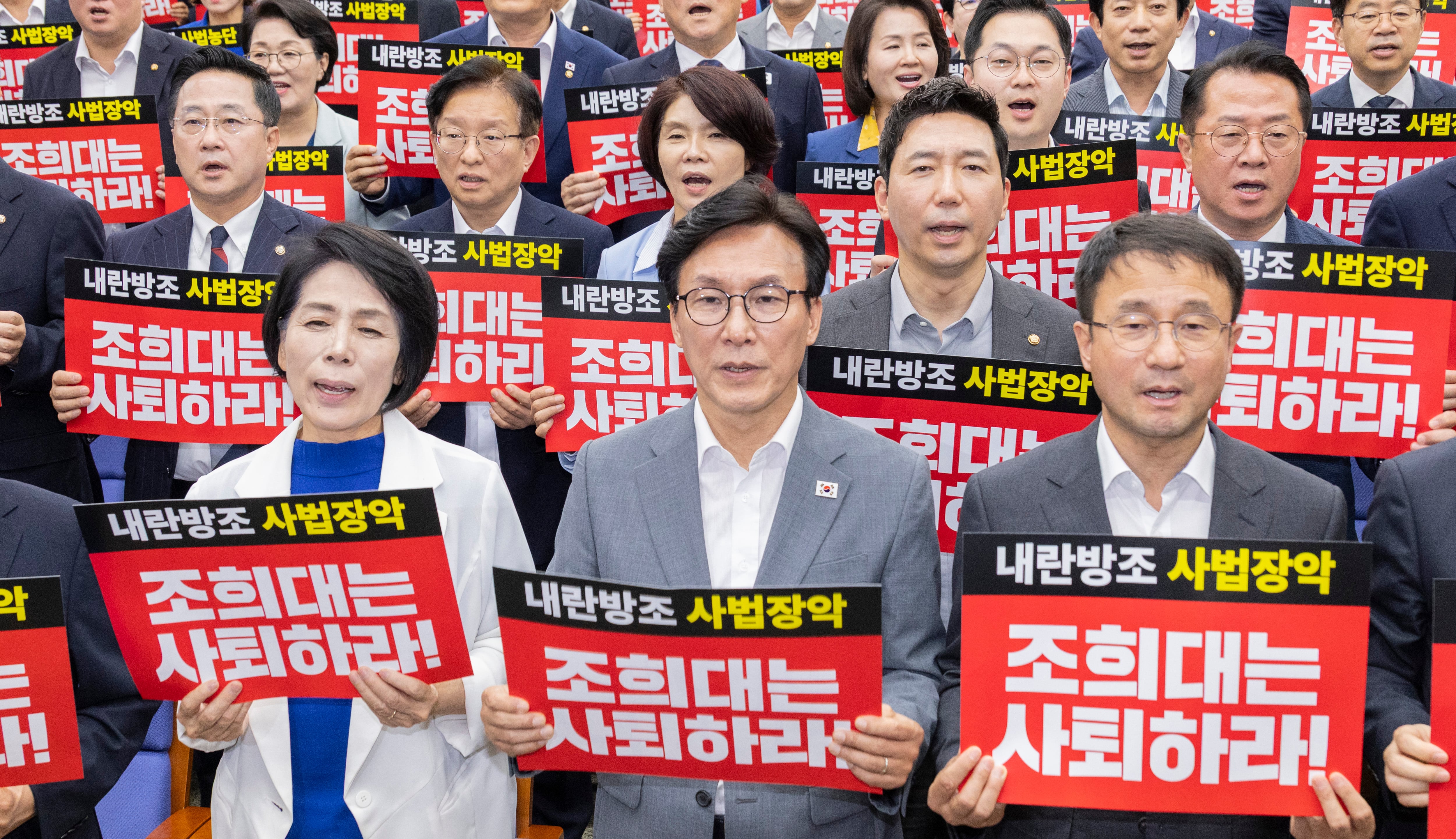 더불어민주당 김민석 대표와 한병도 원내대표, 최고위원들이 20일 국회에서 전당대회 뒤 처음으로 열린 의원 총회에서 조희대 대법원장 사퇴를 촉구하는 손팻말을 든 채 구호를 외치고 있다. 2026.8.20/연합뉴스