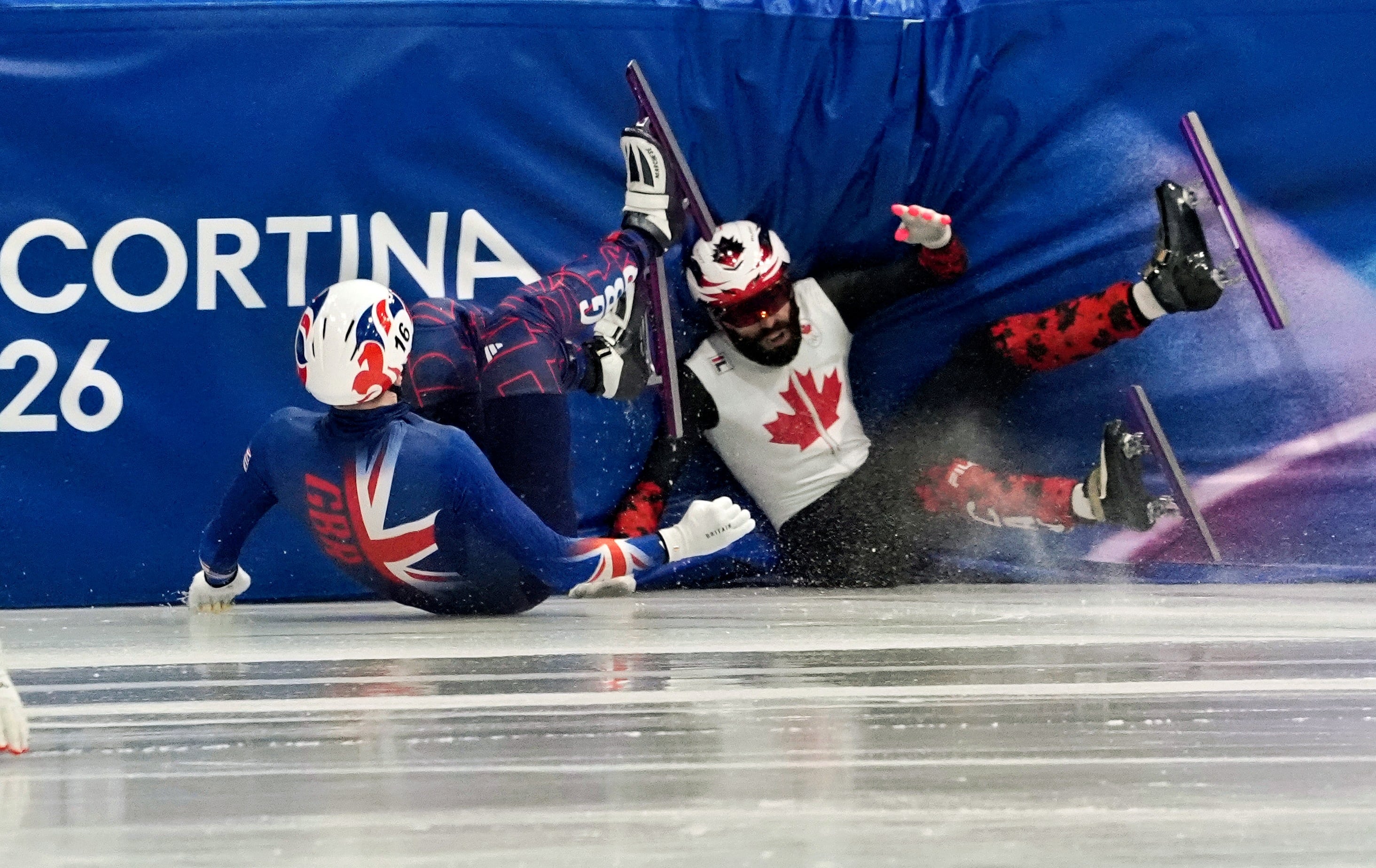 10일 열린 밀라노 코르티나 동계 올림픽 쇼트트랙 남자 1000m 예선 경기에서 영국 니얼 트레이시(왼쪽)와 캐나다 스티븐 뒤부아가 엉켜 넘어지고 있다. 선수들은 이번 대회 쇼트트랙 경기장 빙판이 물러서 적응하기가 쉽지 않다고 입을 모은다./UPI 연합뉴스