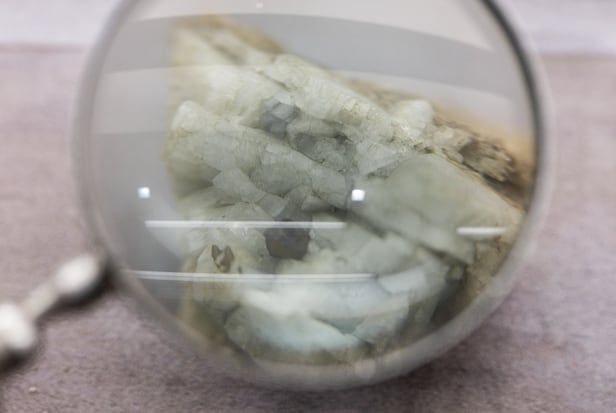 2025년 10월 14일 중국 베이징의 중국지질박물관에, 세륨(Ce)ㆍ란타넘(La)ㆍ네오디뮴(Nd) 등의 희토류 원소를 추출하는 광물인 모나자이트 샘플이 확대경 옆에 전시돼 있다./로이터 연합뉴스