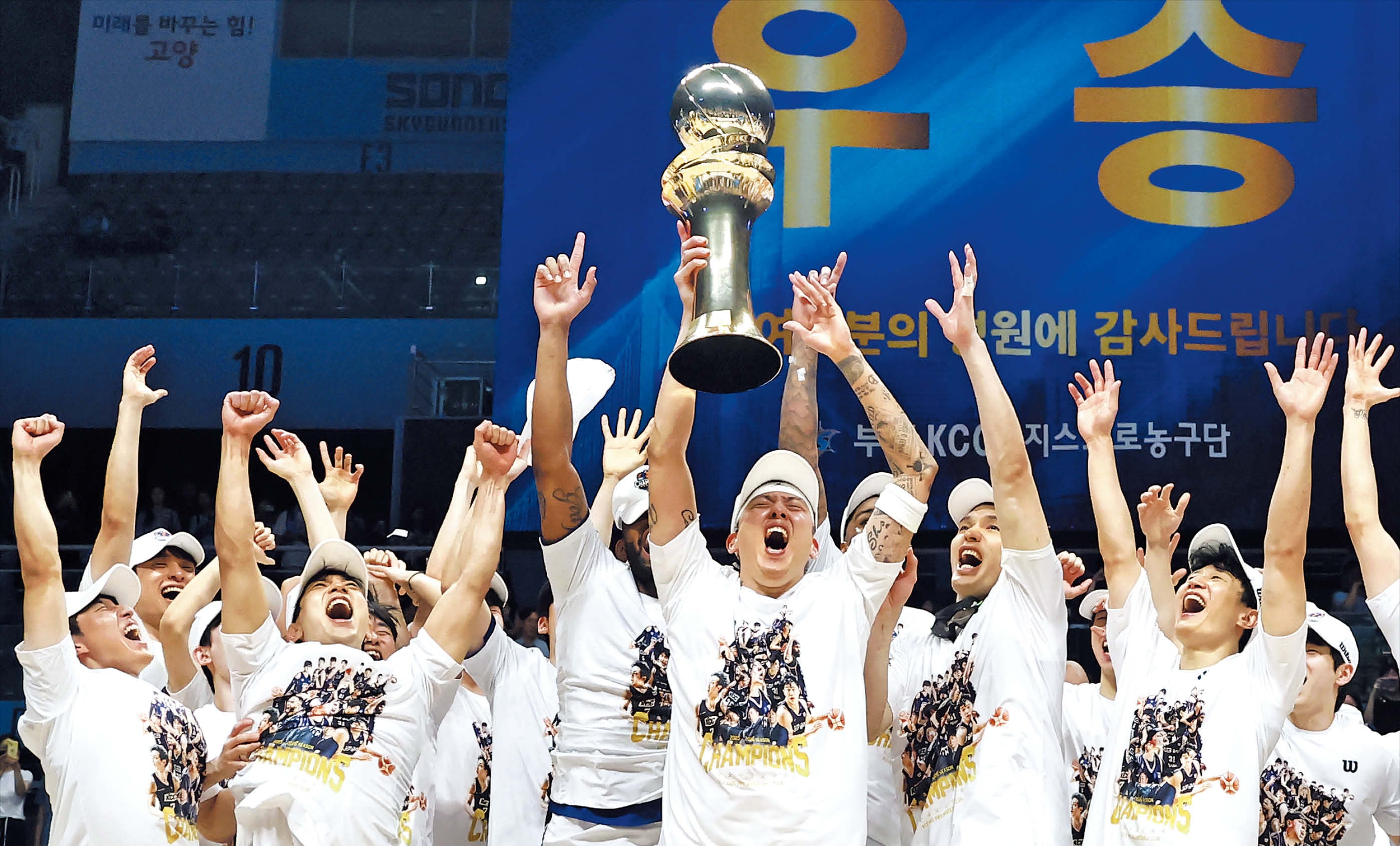 부산 KCC가 13일 프로농구 챔피언결정 5차전에서 고양 소노를 꺾고 시리즈 전적 4승 1패로 우승했다. 주장 최준용이 우승 트로피를 힘차게 들어 올리자 선수단이 환호하고 있다. KCC는 정규리그 6위로 첫 챔프전 우승을 차지한 팀이 됐다. /연합뉴스
