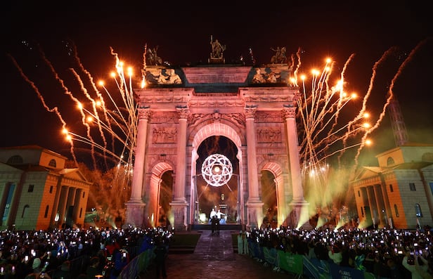 6일 밀라노 코르티나 올림픽 개막식에서 평화의 아치(아르코 델라 파체)에 설치된 성화대에 불이 옮겨붙는 순간 축하 폭죽이 터지고 있다. /로이터 연합뉴스