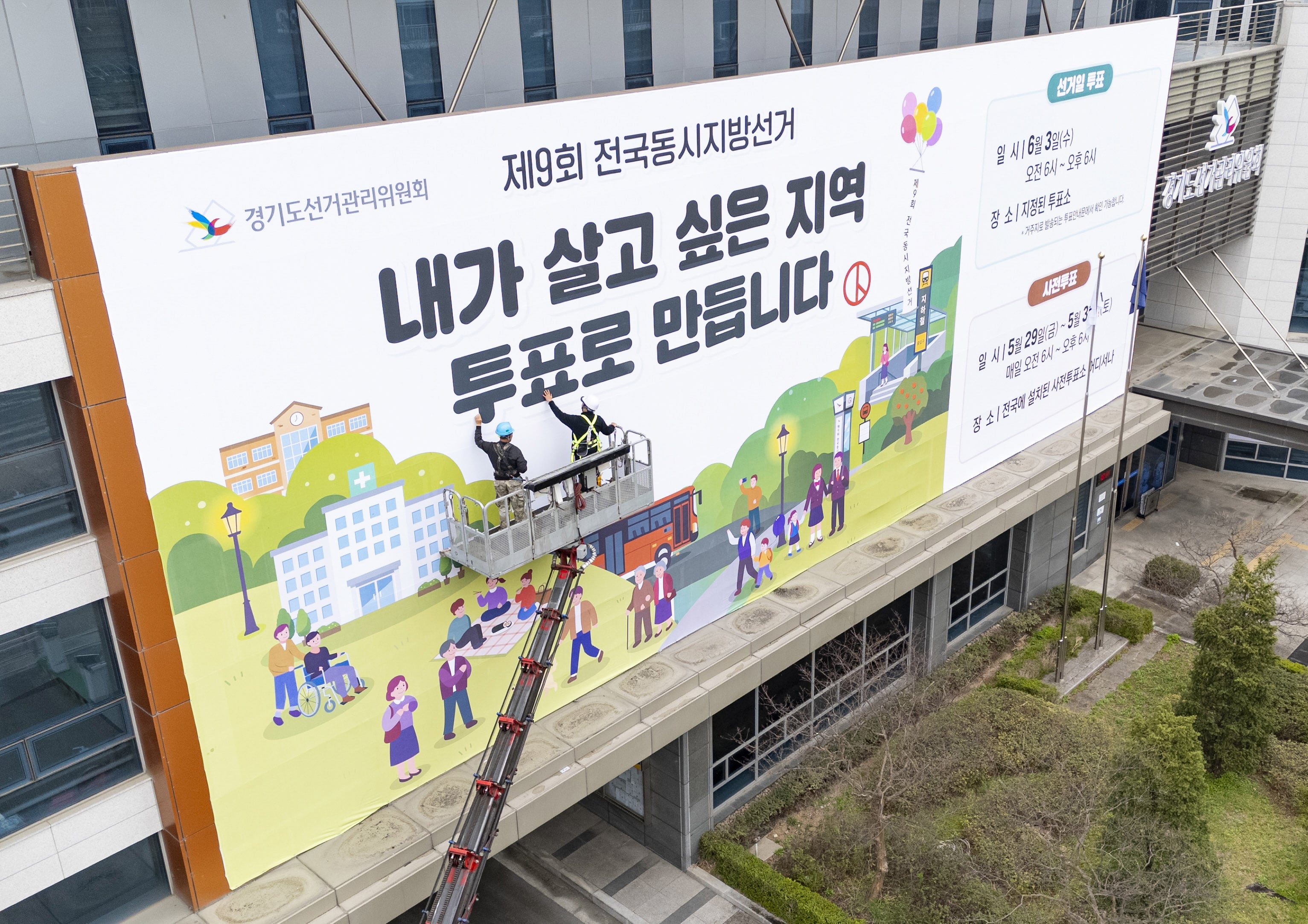 제9회 전국동시지방선거를 앞둔 9일 경기도 수원시 영통구 경기도선거관리위원회 청사 외벽에 관계자들이 투표참여를 독려하는 대형 현수막을 설치하고 있다. /뉴스1