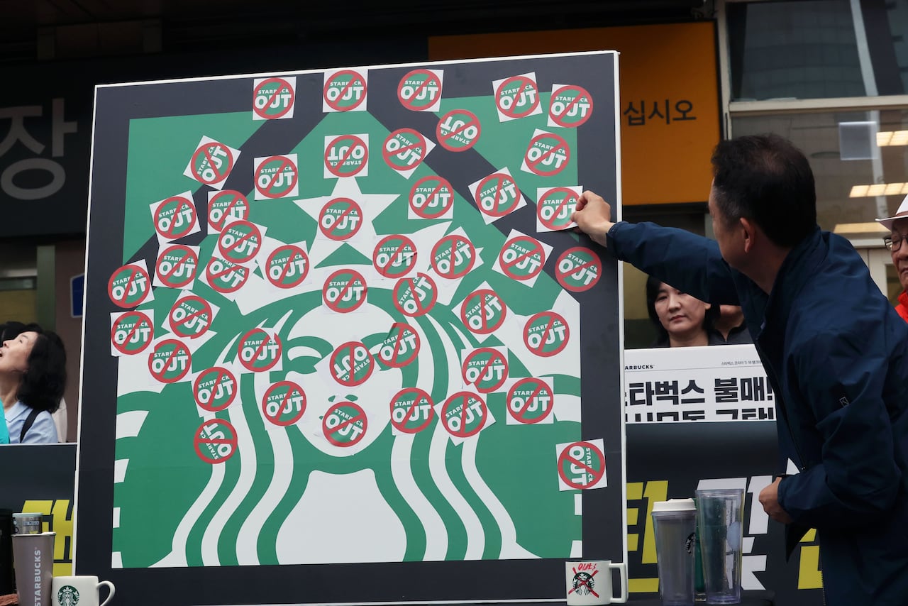 오월을 사랑하는 모임 등 광주시민단체들이 지난 21일 오후 광주 서구 광천동 이마트 광주점 앞에서 스타벅스의 '5·18 탱크데이' 마케팅을 규탄하는 기자회견을 열고 스타벅스 OUT 스티커를 붙이고 있다. /뉴스1