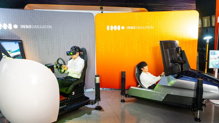 MIK 레이싱의 오한솔(왼쪽)과 한재희가 이노시뮬레이션이 개발한 심레이싱 시뮬레이터를 체험해보고 있다. 사진제공=이노시뮬레이션