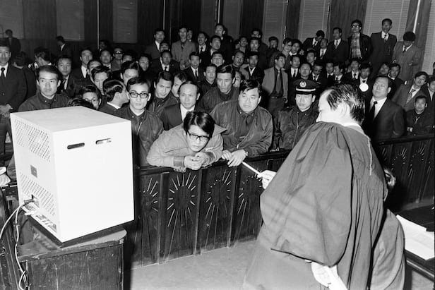 1974년 11월 13일 서울고등법원 법정에서 정치근(오른쪽 법복 입은 이) 부장검사가 육영수 여사 피습 상황을 담은 영상을 설명하고 있다. 수갑을 찬 피고인 문세광(가운데)이 영상을 보며 당황한 표정을 짓고 있다. /조선일보 DB