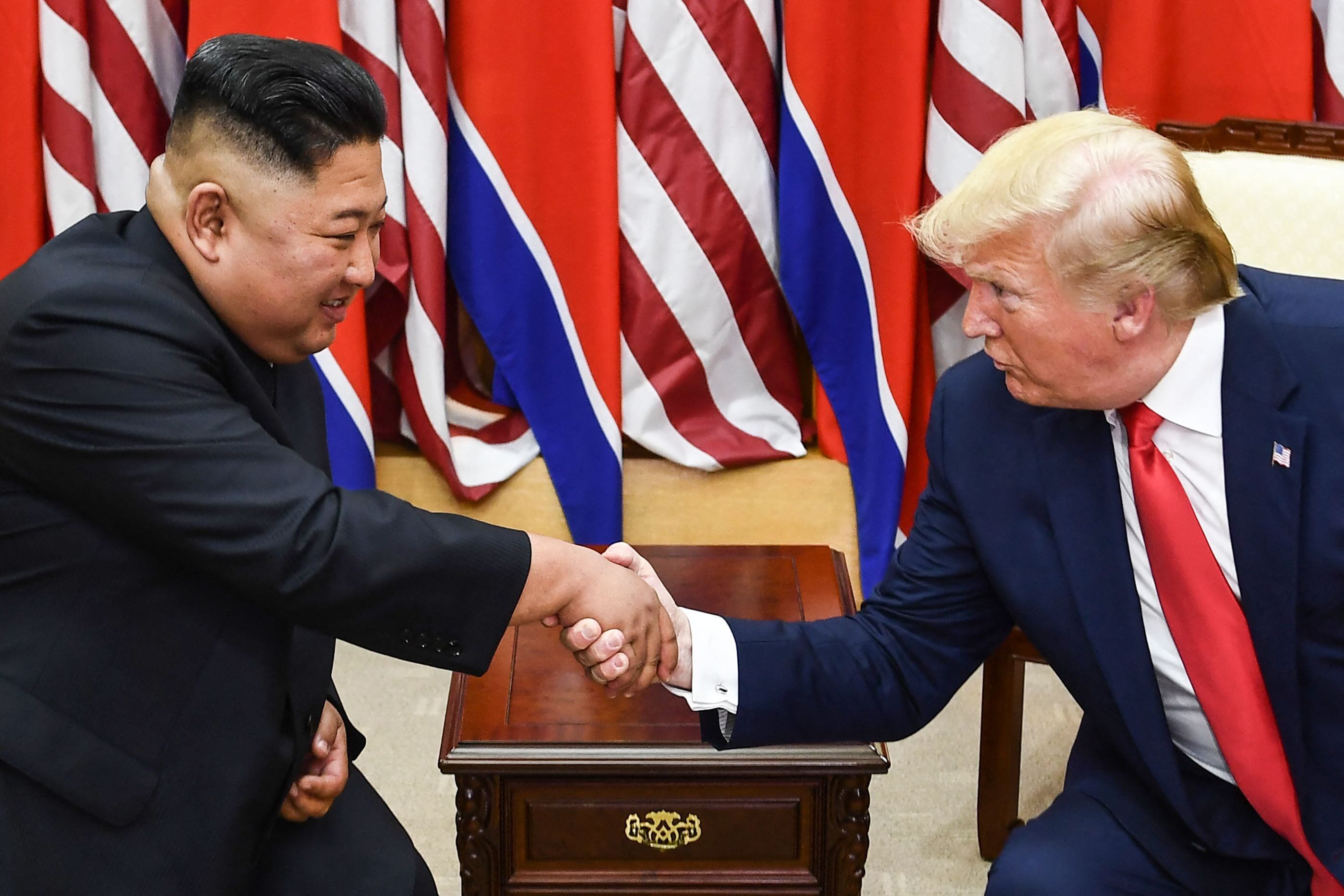 김정은 북한 국무위원장(왼쪽)과 도널드 트럼프 미국 대통령. 사진은 2019년 6월 30일 비무장지대(DMZ) 판문점 공동안전지대(JSA)에서 군사분계선 남쪽에서 열린 회담 중 두 사람이 악수하고 있는 모습. /AFP 연합뉴스