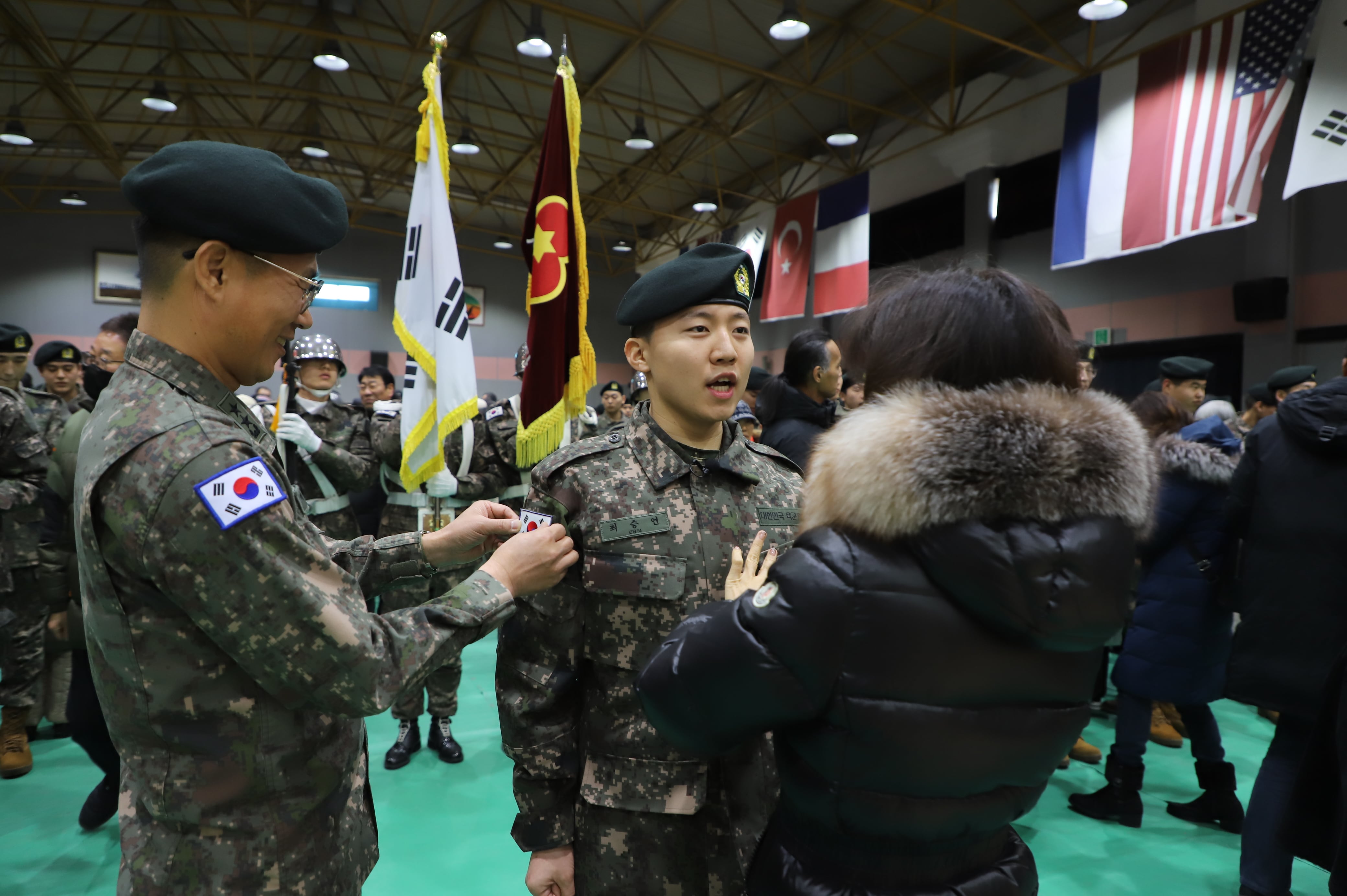 지난달 21일 육군 제36사단 백호 신병교육대대 수료식에서 신병에게 부모님이 계급장을 달아 주고 있다. /연합뉴스