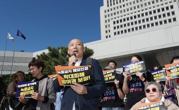 마이크를 쥔 웹툰 작가 주호민씨가 지난 6일 장애인차별금지추진연대 등 10개 장애인 단체와 함께 서울 서초구 대법원 앞에서 기자회견을 열고 “스스로 말하거나 증거를 남기기 어려운 사람에게도 법이 닿을 수 있는 기준을 세워달라”고 촉구하고 있다. 발달장애 아동 등 학대 피해가 의심되는 경우에는 제3자 녹음을 인정해 달라는 취지다. /연합뉴스