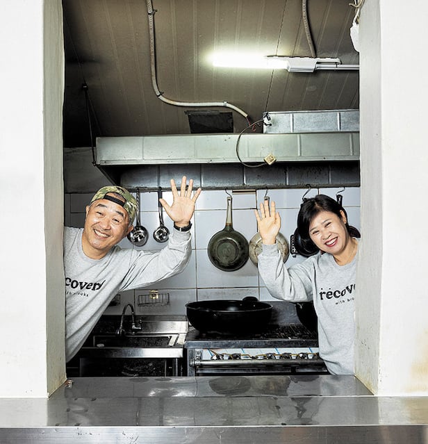 김현일·김옥란씨 부부가 노숙인을 위한 도시락을 다 만들고 나서 부엌 한편에 섰다. 부부는 “IMF 위기를 겪으며 평범하게 세끼 밥 먹고, 돌아갈 집이 있다는 게 얼마나 거룩하고 위대한 일인지 배웠다”고 했다. 부부가 입은 옷은 고립·은둔 청년 회복 기관인 푸른고래 리커버리에서 만든 티셔츠다. /양수열 영상미디어 기자