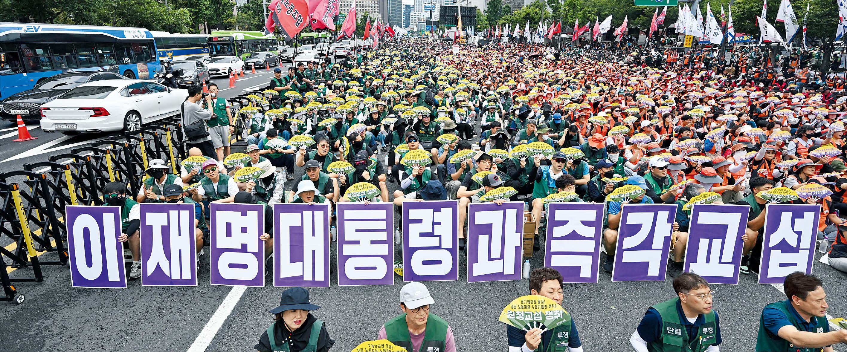 지난 7월 15일 오후 서울 광화문 일대에서 민주노총이 총파업 집회를 열었다. 노란봉투법 시행 후 첫 대규모 파업 집회였다. 사진은 참가자들이 ‘이재명 대통령과 즉각 교섭’이라고 적힌 대형 팻말을 든 모습. 이들은 “(공공부문에서) 모범 사업자를 자처하는 정부가 하청 노조 교섭에 응하지 않는 건 모순”이라며 정부 수장인 이 대통령이 나설 것도 요구했다./ 박성원 기자
