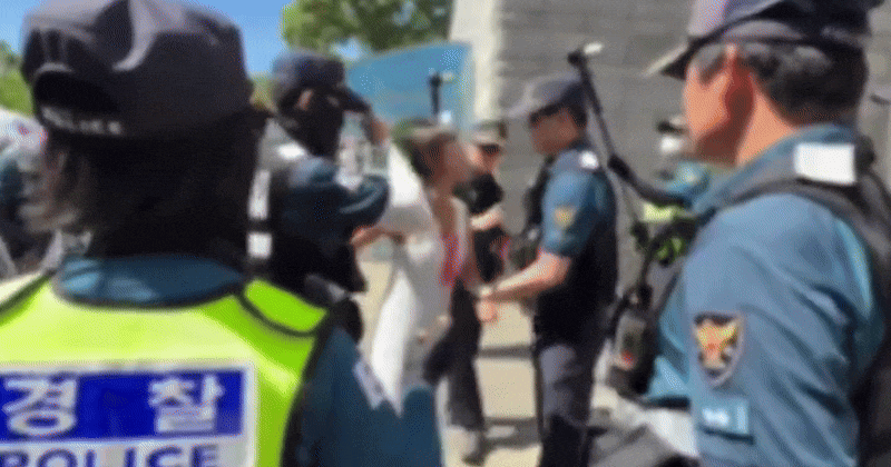 Woman in pink at the Jamsil voting-rights rally leaving the court after detention hearing