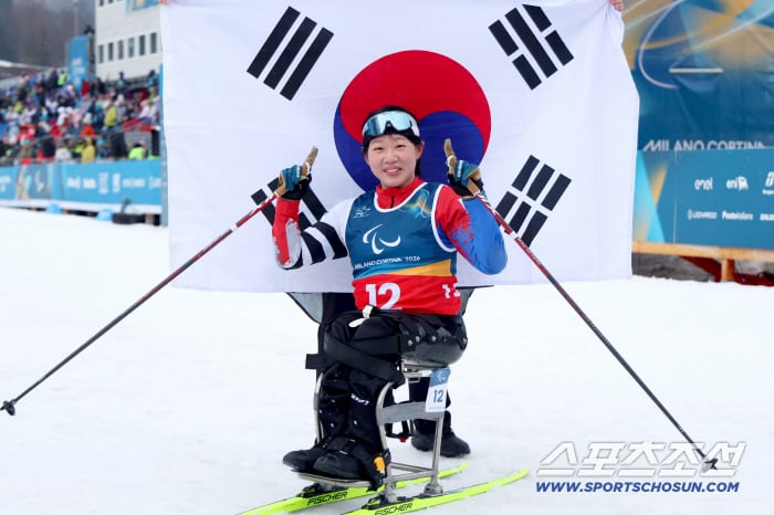 김윤지가 15일 이탈리아 테세로 크로스컨트리 스타디움에서 열린 크로스컨트리 스키 여자 20㎞ 인터벌 스타트 좌식에서 58분23초3의 기록으로 사상 첫 패럴림픽 2관왕에 오른 후 태극기 앞에서 활짝 웃고 있다. 사진제공=대한장애인체육회