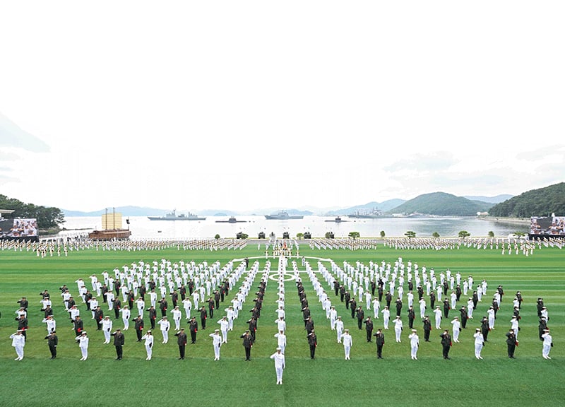 지난 5월 28일 경남 창원시 진해구의 해군사관학교 연병장에서 거행된 ‘제140기 해군·해병대 사관후보생 수료 및 임관식’. 연병장 앞으로 진해만 위에 떠있는 해군 함정과 거북선(왼쪽)이 보인다. photo 뉴시스