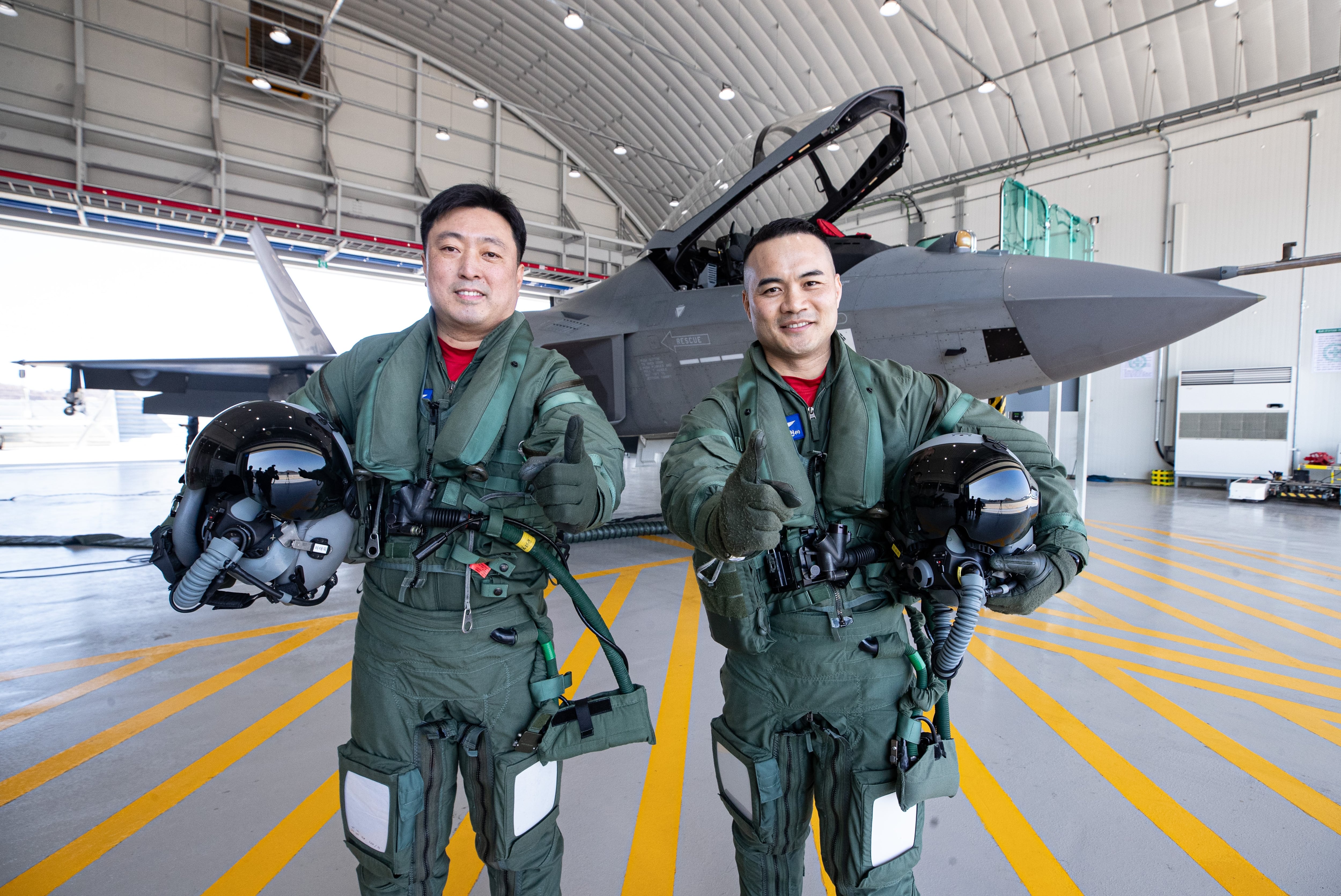 경남 사천 한국항공우주산업(KAI)에서 만난 시험비행조종사 안준현(왼쪽), 전승현 중령. 제281 시험비행대대 전현직 대대장이기도 한 이들이 국산 초음속 전투기 KF-21 앞에서 대대 구호인 '우리가 처음이다'를 외치고 있다. /김동환 기자