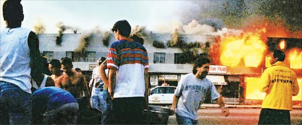LA폭동 둘째 날인 1992년 4월 30일 밤, 주민들이 상가의 불을 끄기 위해 양동이에 물을 채워 나르고 있다. 이 사태로 54명이 사망하고, 2300명 이상이 부상했으며, 3600건의 화재가 발생했다. /게티이미지코리아