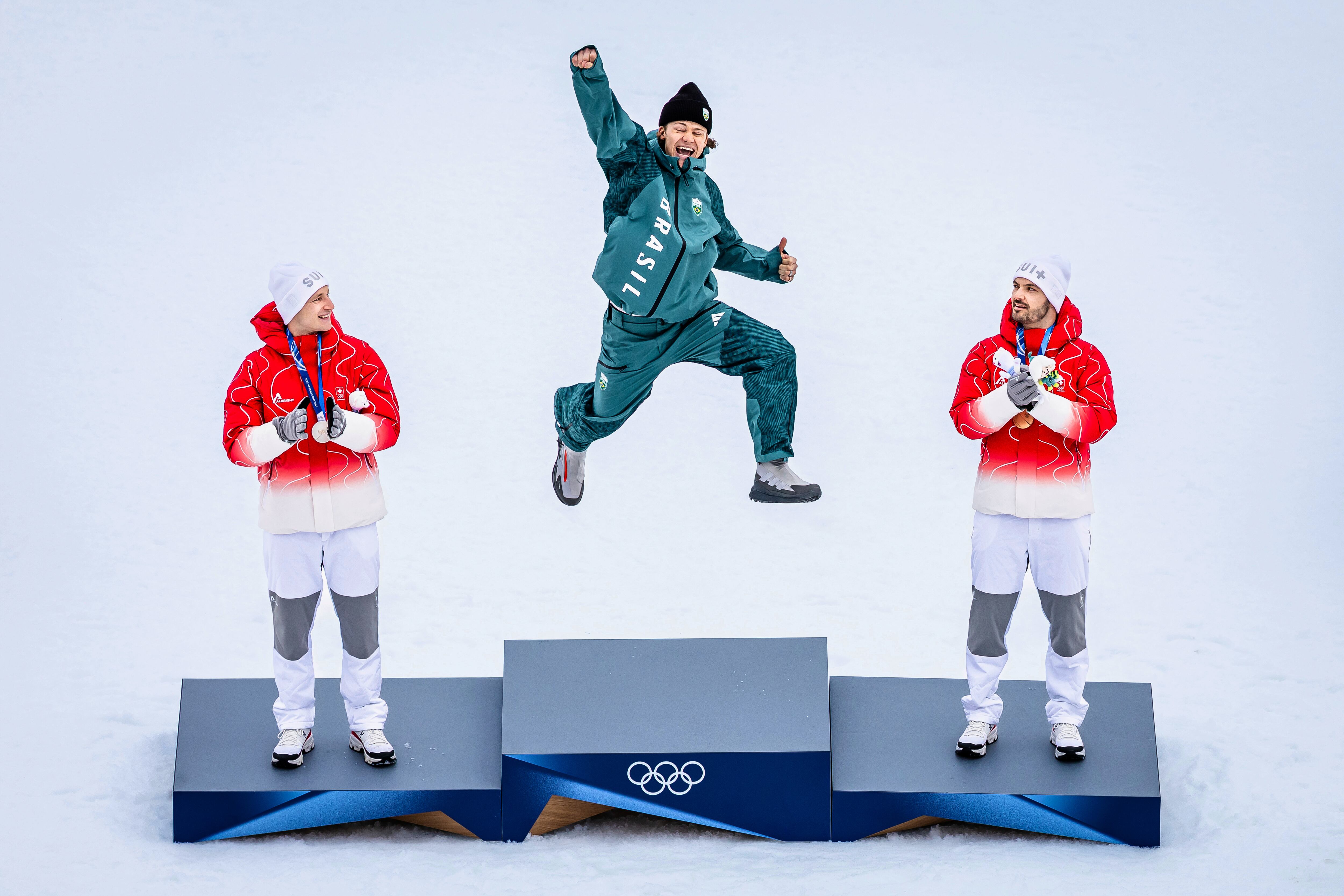 지난 14일 이탈리아 보르미오에서 열린 2026 동계 올림픽 알파인 스키 남자 대회전에서 우승한 브라질의 루카스 피녜이루 브라텡(가운데)이 시상대에서 감격의 '도약'을 선보이고 있다. /AP 연합뉴스