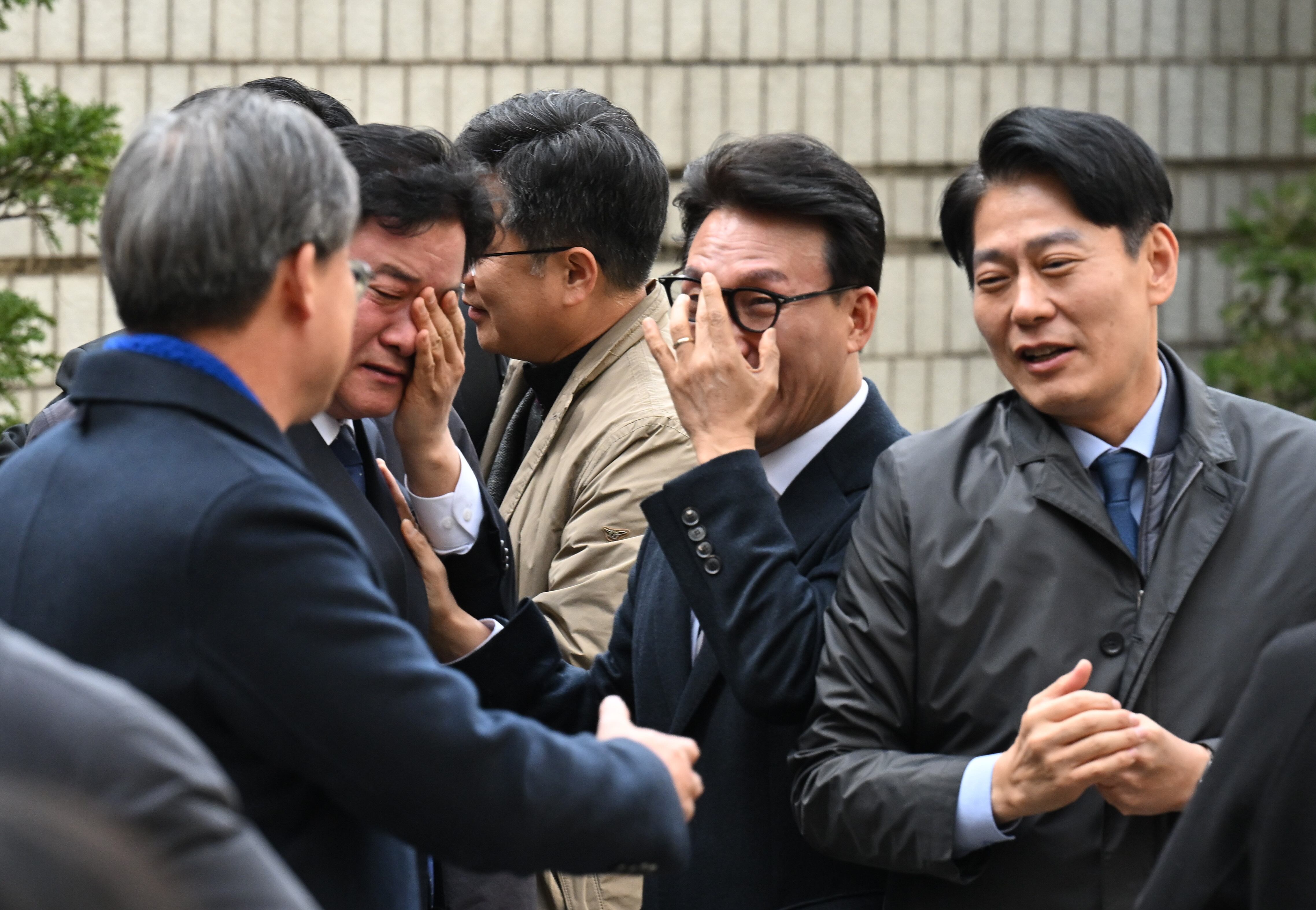 더불어민주당 이재명 대표가 25일 서울중앙지법에서 열린 위증 교사 사건 1심 공판에서 무죄를 선고받았다는 사실이 알려지자, 법원 건물 앞에서 이 대표를 기다리던 민주당 윤종군(왼쪽에서 둘째) 의원이 눈물을 훔치고 있다. 이날 민주당 의원 60여 명이 법원 앞에 모여 이 대표를 응원했다. /사진공동취재단