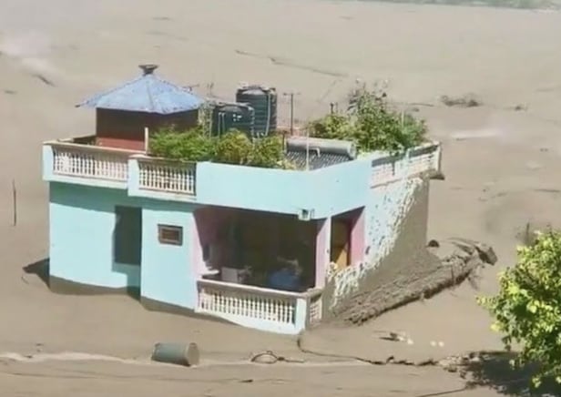 지난 26일 네팔 대홍수로 주변 건물들이 쓸려간 가운데 초록빛 집 한 채는 끝까지 무너지지 않고 자리를 지켰다./소셜미디어 X 캡처