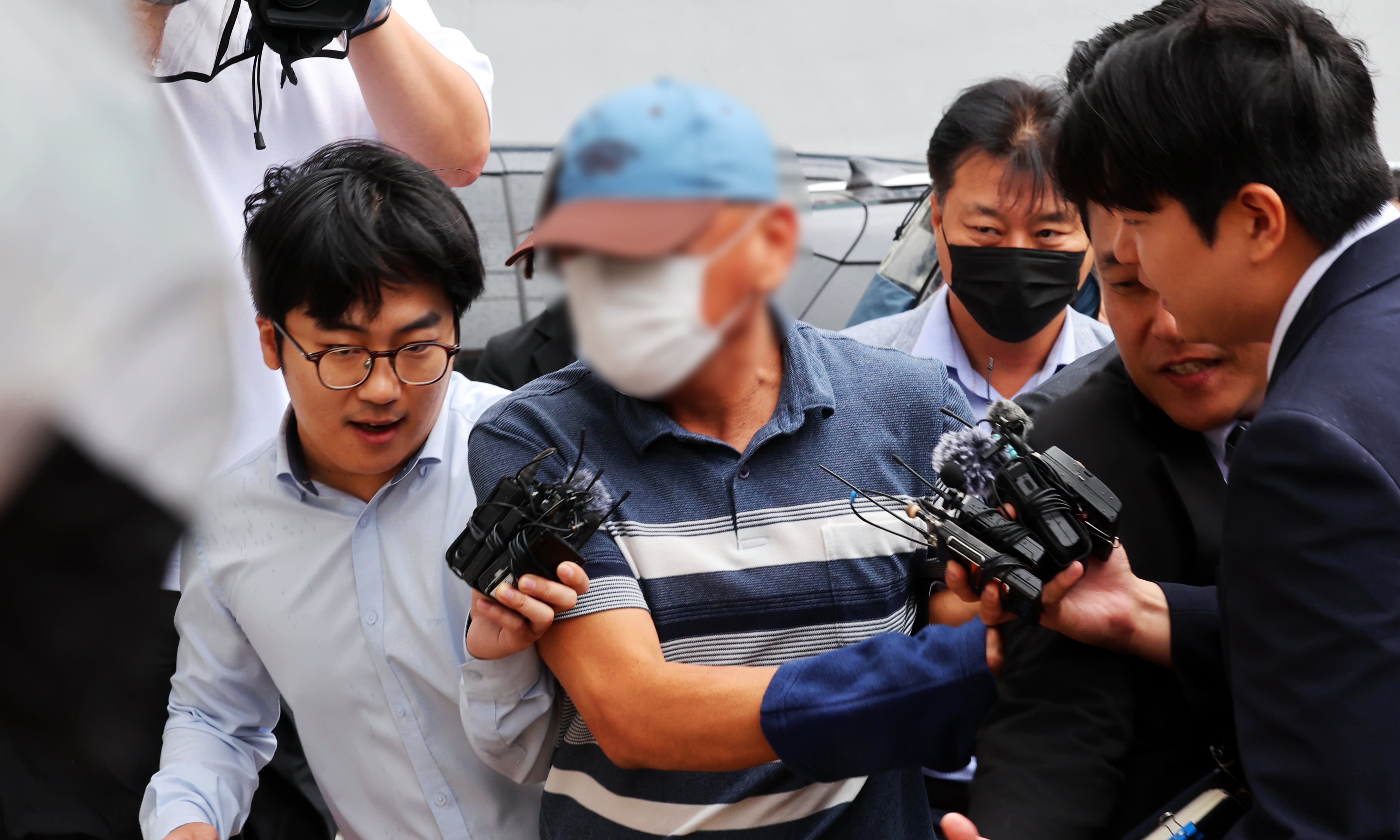 전남광주 '여고생 살인사건' 범인 장윤기 관련 수사 정보를 유출한 혐의 등을 받고 있는 광산경찰서 수사팀장이 지난달 8일 구속영장 실질심사를 받기 위해 법원에 들어가며 취재진을 뿌리치고 있다. 그는 이달 3일 구속 기소됐다. /연합뉴스
