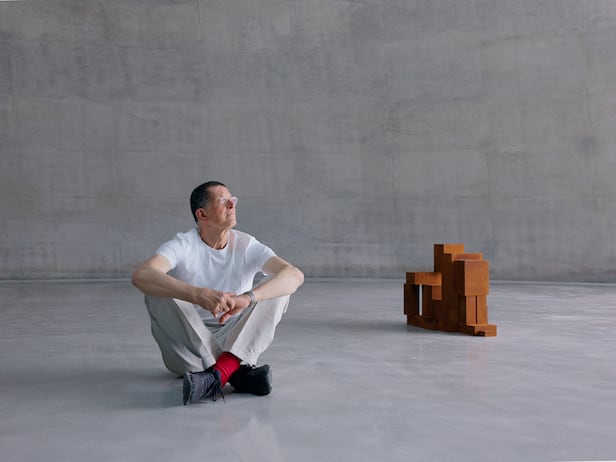 자신의 첫 상설 전시관 ‘Ground’에 앉은 조각가 앤터니 곰리. 그는 “공간과 작품이 함께 성장하는 경험을 처음 하게 됐다”고 했다. 옆엔 무릎을 모으고 뒤로 기댄 사람 모습을 표현한 그의 조각./뮤지엄 산
