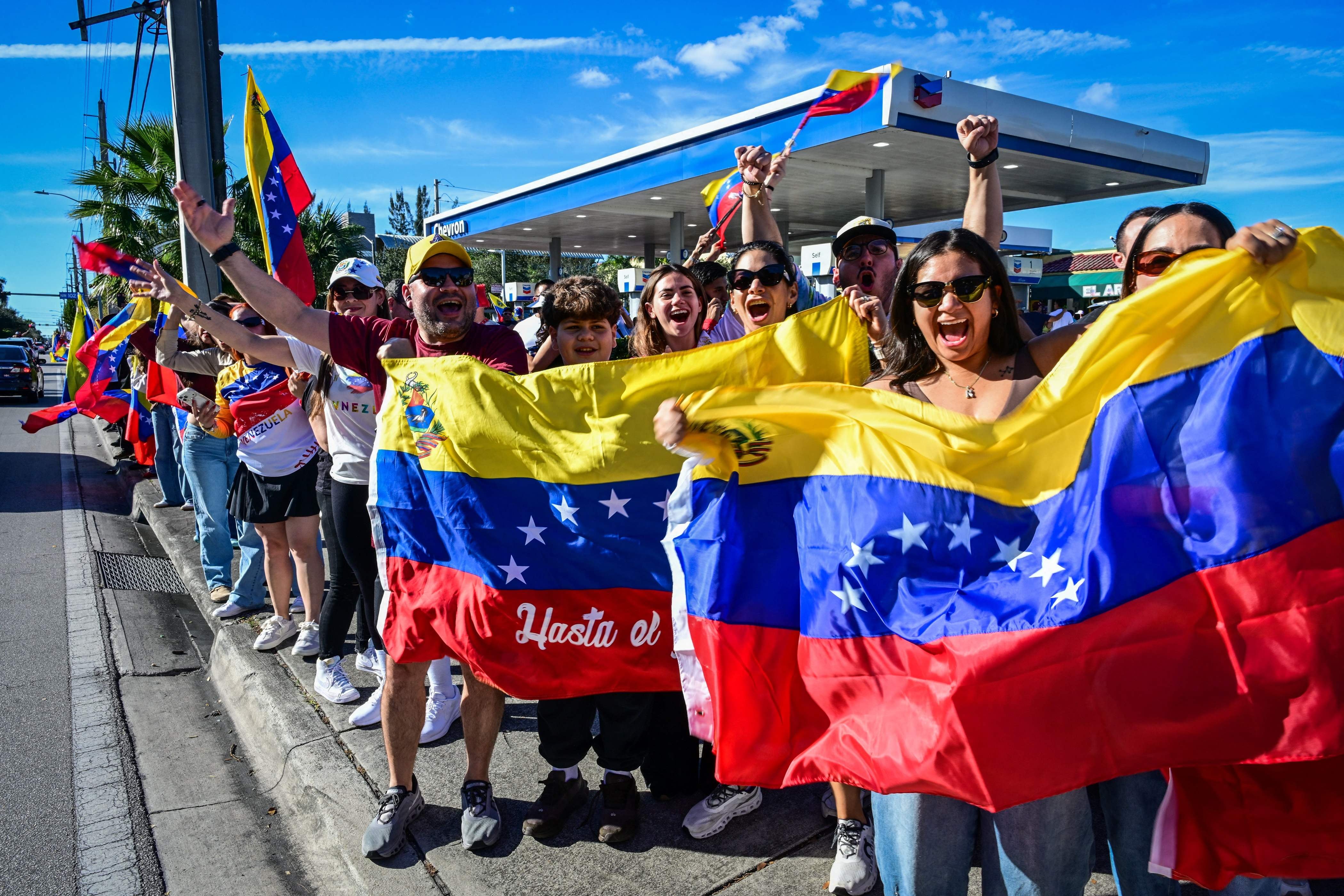 베네수엘라 독재 정권을 피해 미국 플로리다주 도랄에 체류중인 베네수엘라 사람들이 니콜라스 마두로 대통령의 체포 소식이 알려진 3일 거리로 나와 베네수엘라 국기를 흔들며 환호하고 있다. /AFP 연합뉴스