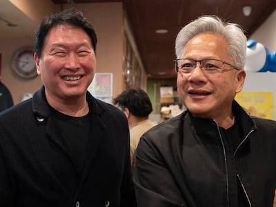 지난달 5일(현지 시각) 미국 캘리포니아 산타클라라의 한국식 호프집 '99치킨'에서 가진 최태원 SK그룹 회장과의 만찬회동에서 젠슨 황 엔비디아 최고경영자가 신간 '슈퍼모멘텀'을 펼쳐보이고 있다. / 연합뉴스