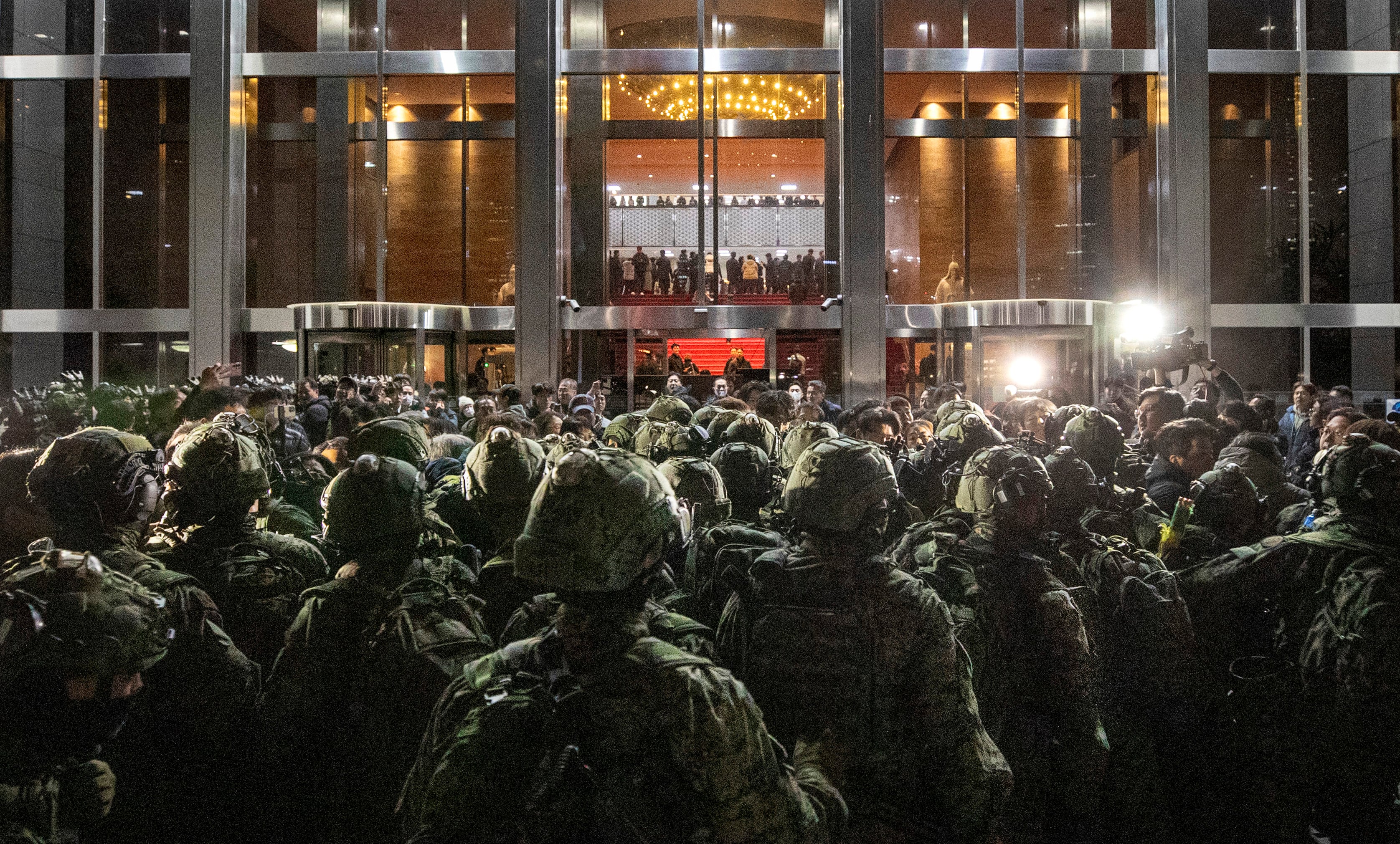2024년 12월 4일 새벽, 계엄군이 국회 본관 정문 앞에서 국회 사무처 직원, 보좌진 등과 대치하고 있다. 계엄군은 정문이 막히자 사무실 유리창을 깨고 진입했지만, 의원들이 계엄 해제 요구안 표결을 위해 모인 본회의장에 들어가지는 않았다. 이날 국회에 투입된 병력은 약 280명으로 추정된다. / 김지호 기자