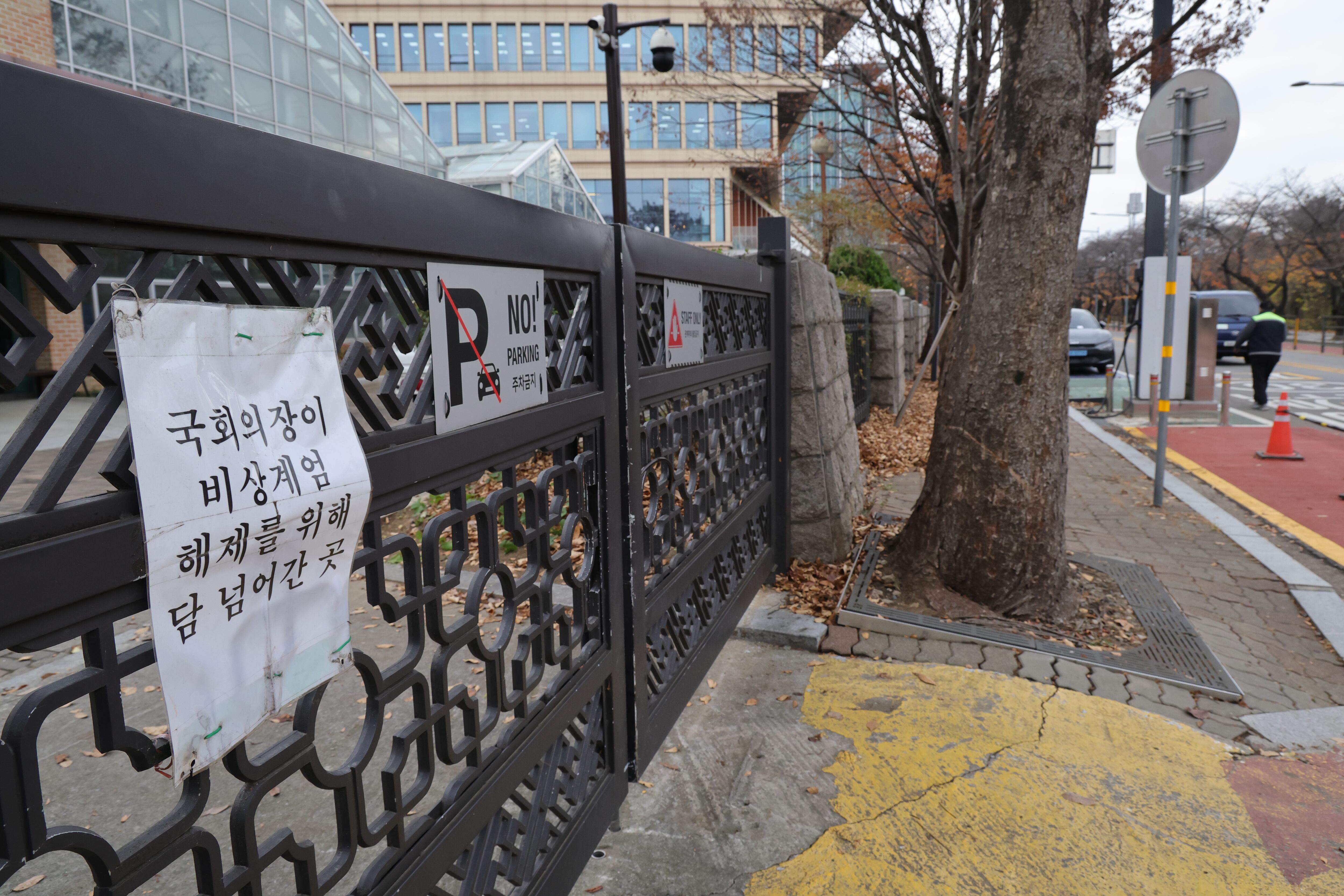 26일 서울 여의도 국회 외곽 철제 문에 ‘우원식 국회의장이 비상계엄 해제를 위해 담 넘어간 곳’이란 문구의 표지판이 걸려있다. 국회는 계엄 1년을 맞아 각종 행사 등에 최소 4억3100여 만원의 예산을 쓸 것으로 알려졌다./남강호 기자